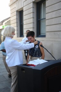 Mary Ellen Sprague puts the medal around Jen Colestock's neck
